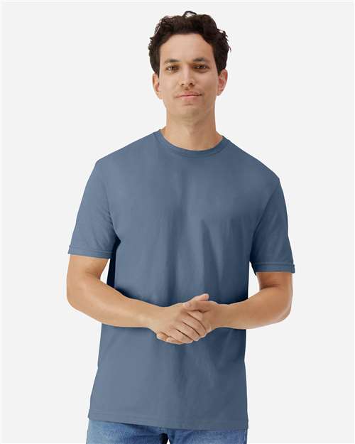 Model wearing a Gildan 3000 Unisex Light Cotton T-Shirt in a neutral color, showcasing its casual design.