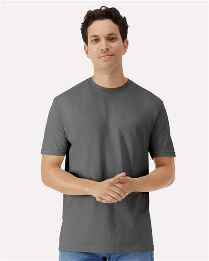 Model wearing a Gildan 3000 Unisex Light Cotton T-Shirt in a neutral color, showcasing its casual design.