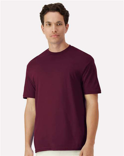 Model wearing a Gildan 3000 Unisex Light Cotton T-Shirt in a neutral color, showcasing its casual design.