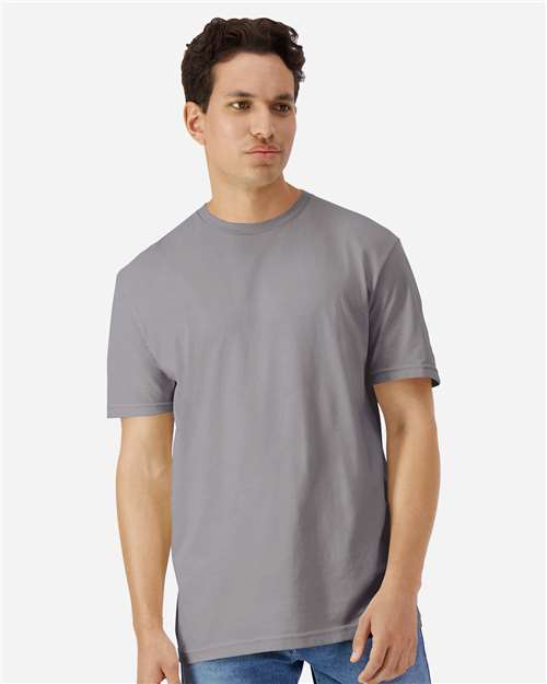 Model wearing a Gildan 3000 Unisex Light Cotton T-Shirt in a neutral color, showcasing its casual design.Model wearing a Gildan 3000 Unisex Light Cotton T-Shirt in a neutral color, showcasing its casual design.