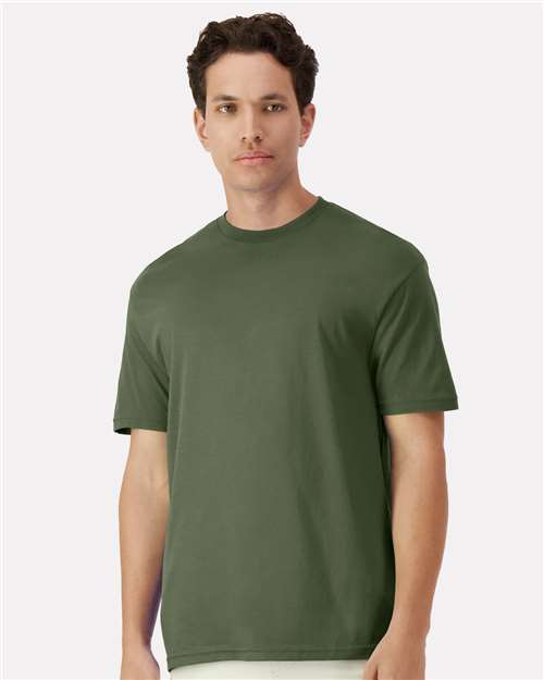 Model wearing a Gildan 3000 Unisex Light Cotton T-Shirt in a neutral color, showcasing its casual design.